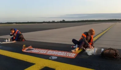 Kendilerini apronlara yapıştıran eylemciler hava trafiğini aksattı